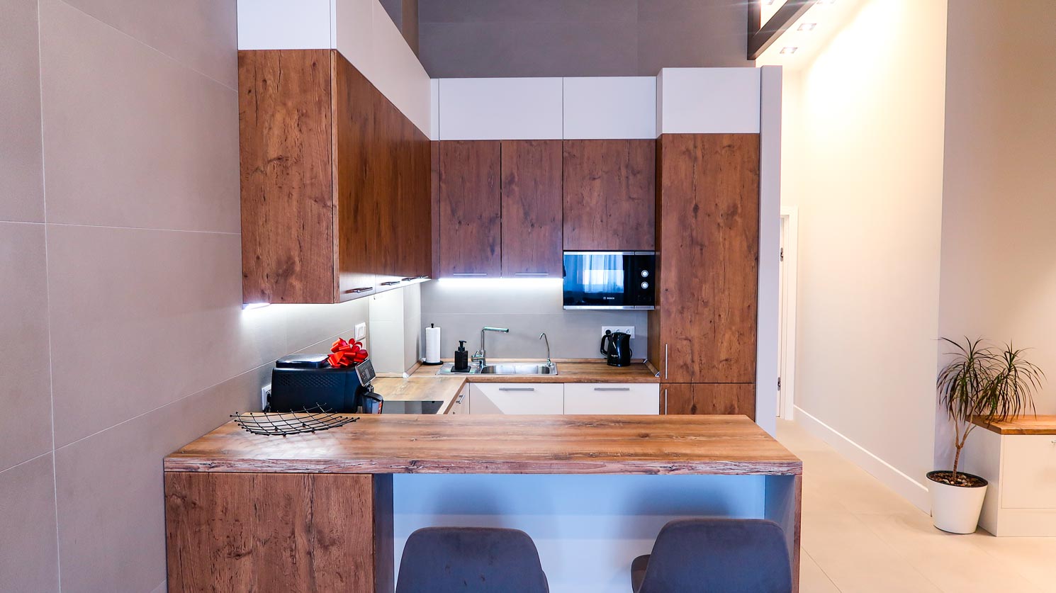 Решение для квартиры с потолками переменной высоты: двухуровневая кухня и встроенные шкафы