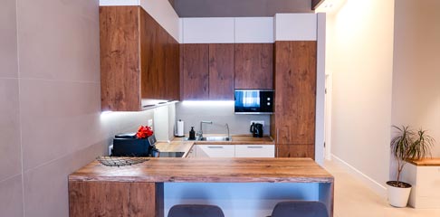 Решение для квартиры с потолками переменной высоты: двухуровневая кухня и встроенные шкафы